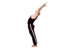 a woman in black pants and tank top doing a yoga pose with her hands up