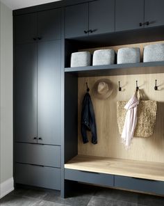 a coat rack with hats and coats hanging on it's hooks, next to a bench