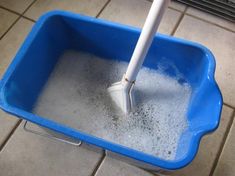 a mop in a blue bucket filled with water