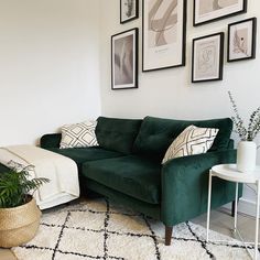 a living room with green couches and pictures on the wall above it's coffee table