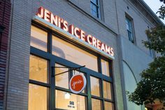 an ice cream shop front with the window lit up at night and there is a sign that says jenny's ice creams