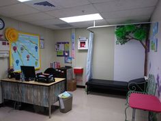 a classroom with desks, chairs and a tree on the wall