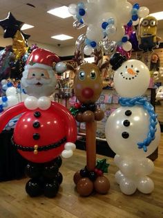 two inflatable snowman and santa clause balloon sculptures on display at a store