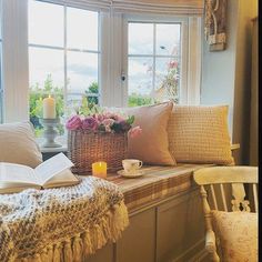 a window sill filled with books and flowers next to a basket full of roses