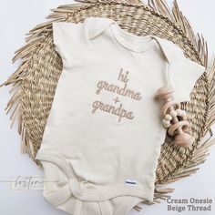 a baby's bodysuit with the words grandma and grandpa written on it next to a wicker basket