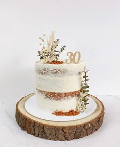 a white cake sitting on top of a wooden slice