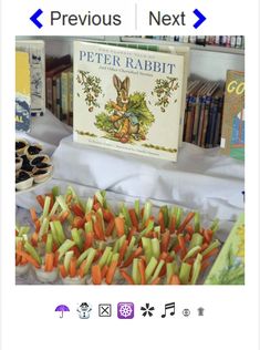 a table topped with lots of veggies next to a bookshelf filled with books