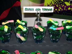 there are many glasses that have different colored candy in them and one has a name tag on it