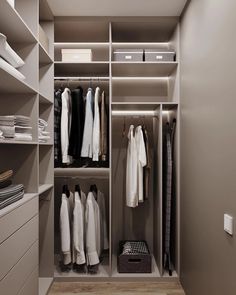 a walk in closet with clothes hanging on the shelves and drawers, along with other items