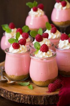 small desserts with whipped cream and raspberries on a wooden platter, ready to be eaten