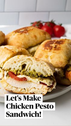 a white plate topped with sandwiches covered in pesto and cheese next to bread rolls