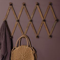 a purse and coat hang on a wall