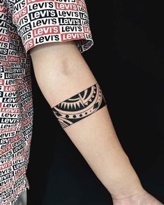 a woman's arm with a black and white tattoo design on her left wrist