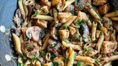 pasta with chicken, mushrooms and parsley in a skillet