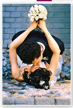 a man and woman are holding each other in the air with flowers on their heads