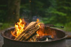 two children sitting in front of a fire pit with flames coming out of the top