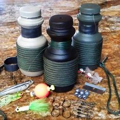 three water bottles sitting on top of a counter next to fishing lures and hooks