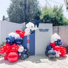 balloons and streamers decorate the entrance to an event in front of a fenced area