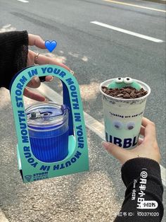 a person holding up a cup of coffee and a sign that says i'm in your mouth