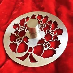 a metal object sitting on top of a red cloth covered table with white trimming