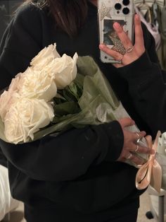 a woman taking a selfie with her cell phone and holding a bouquet of flowers