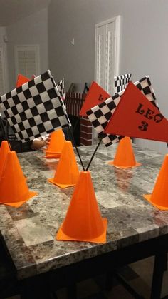 there are many orange cones on the table with checkered flags in them and one is upside down