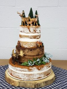 a three tiered cake decorated with deer and trees