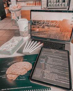 an open laptop computer sitting on top of a table next to a cup of coffee