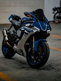 a blue and white motorcycle parked in a parking lot