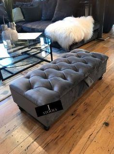 a living room filled with furniture and a glass coffee table on top of a hard wood floor