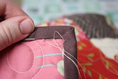 a person is stitching something on a piece of fabric