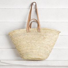 Both sturdy and functional, this Moroccan tote resembles a classic French Market Basket. Can be carried by hand or on the shoulder with the two leather strap options that are hand stitched. Measures approximately 12" high x 18" wide x 9" deep. Handwoven in Morocco Made with palm leaves Big Shopper Bag, Moroccan Market, Summer Basket, Woven Beach Bags, Moroccan Basket, French Market Basket, Market Basket, French Market, Market Baskets