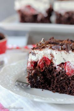 a piece of chocolate cake with whipped cream and cherries is on a white plate