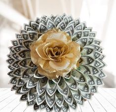 a flower made out of dollar bills sitting on top of a table