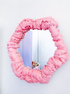 a mirror that is made out of pink paper and some kind of thing on the wall