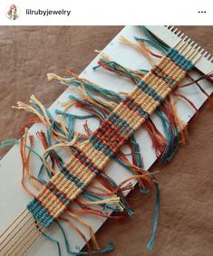 an old weaving loom is laying on top of a piece of paper with yarn