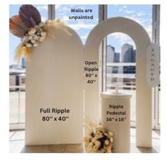 two white headstones with flowers on them in front of large windows and cityscape