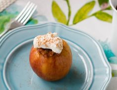 an apple is sitting on a blue plate next to a cup of coffee and silverware