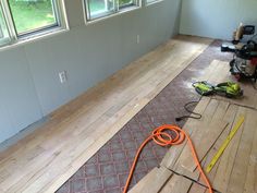 a room with hard wood flooring and construction tools on the floor next to it