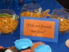 fish are friends, not food on display at an ocean themed birthday party with cupcakes and candy