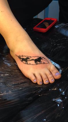 a woman's foot with a horse tattoo on the side of her left foot