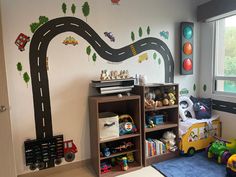 a child's room with cars and trucks painted on the wall, along with toys