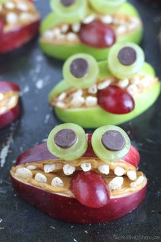 some apples with googly eyes and grapes on them are ready to be made into snacks