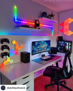 a computer desk topped with a monitor and two gaming headset on top of it