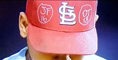 a man wearing a red baseball cap with the st louis cardinals on it's side