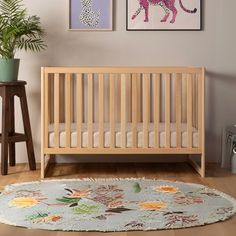 a baby's room with two pictures on the wall and a rug in front of it