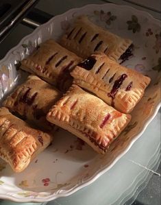 several pastries are on a plate with some sauce in the middle and one has been cut into small pieces