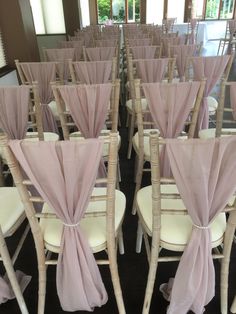 rows of white chairs with pink sashes and bows