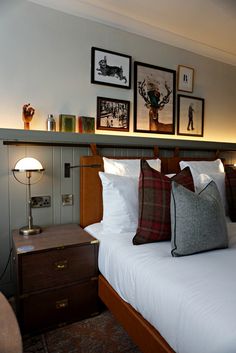 a bed with pillows and pictures on the wall above it