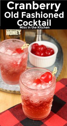 the cranberry old fashioned cocktail is garnished with cherries